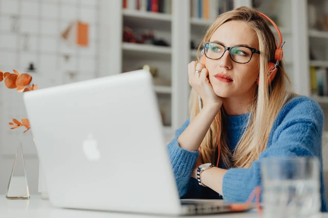 Thoughtful woman in front of her laptop evaluating a conscious purchasing decision